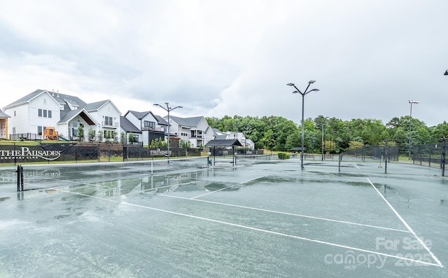 view of sport court with a residential view and fence