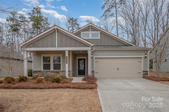 craftsman-style home featuring board and batten siding, stone siding, concrete driveway, and a garage