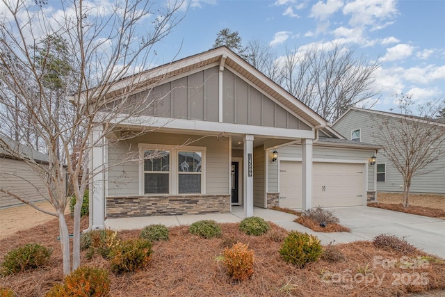 view of front of home with a garage, driveway, stone siding, a porch, and board and batten siding