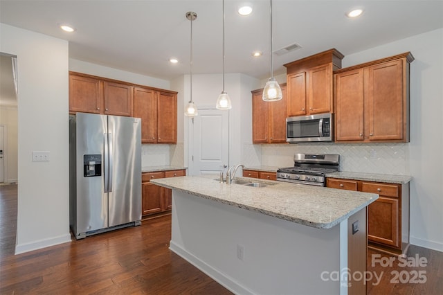 kitchen featuring appliances with stainless steel finishes, brown cabinetry, visible vents, and a sink