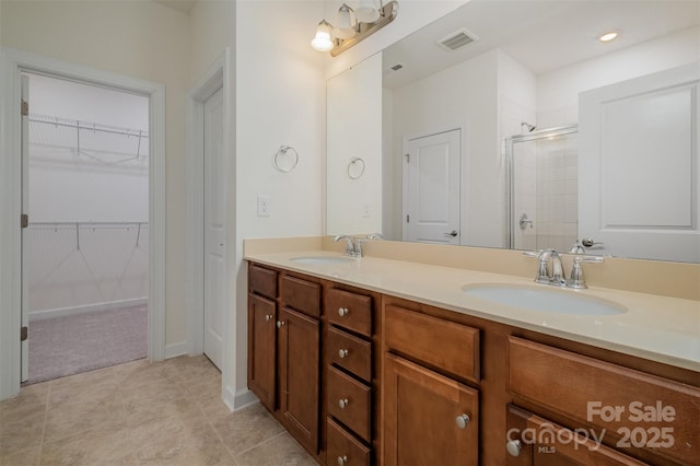 full bathroom featuring a stall shower, visible vents, a sink, and double vanity