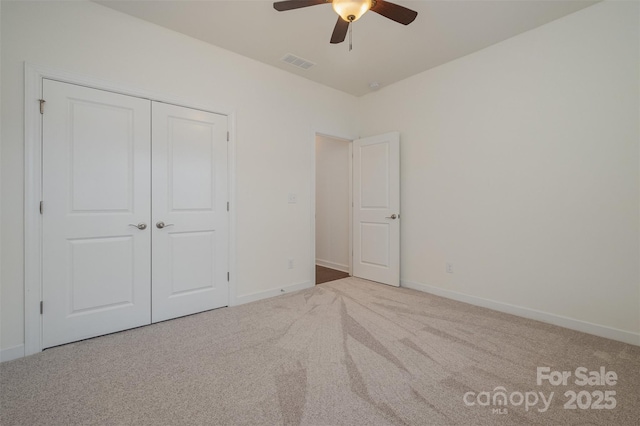 unfurnished bedroom with carpet floors, a closet, visible vents, and baseboards