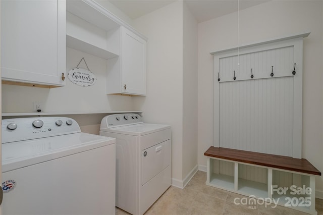 laundry room with cabinet space, attic access, light tile patterned floors, baseboards, and washing machine and clothes dryer