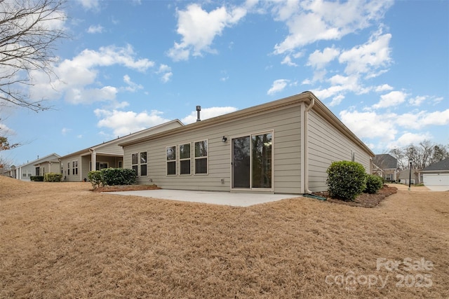 back of property featuring a yard and a patio area