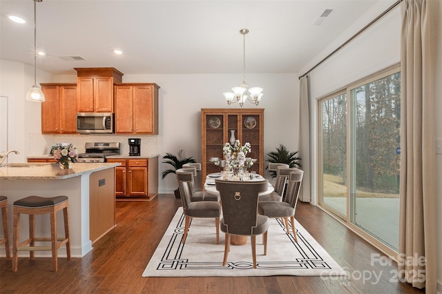 dining room with an inviting chandelier, visible vents, dark wood-style flooring, and recessed lighting