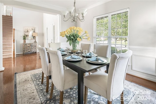 dining space with crown molding, dark wood-type flooring, and a notable chandelier