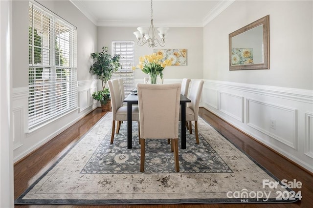 dining area featuring hardwood / wood-style flooring, crown molding, and a chandelier