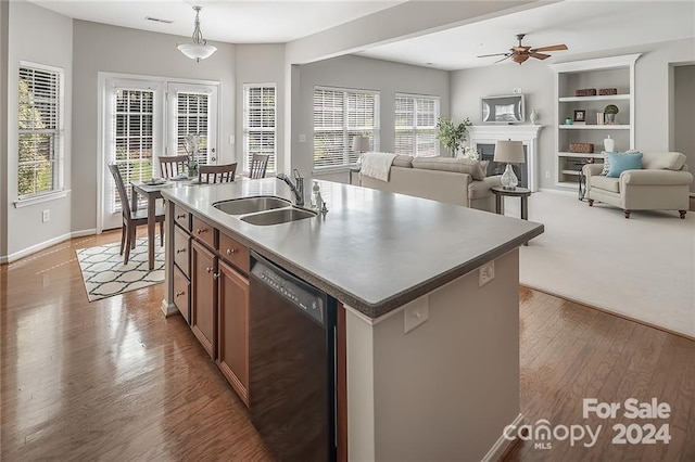 kitchen featuring a wealth of natural light, dishwasher, a center island with sink, and sink