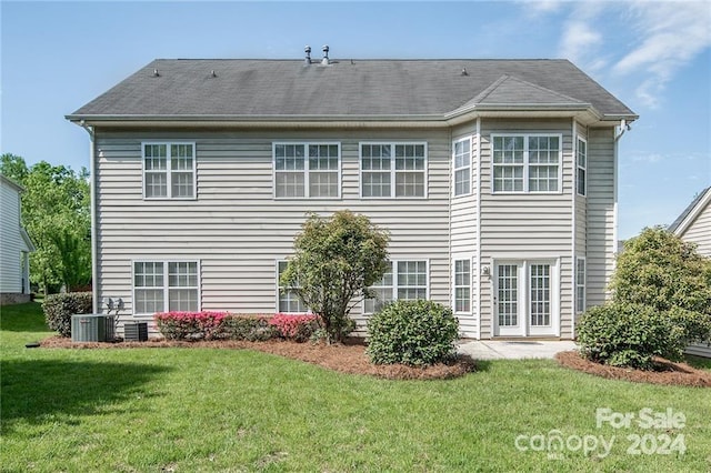 back of property featuring a yard and central AC