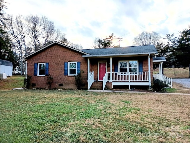 ranch-style house featuring covered porch and a front yard