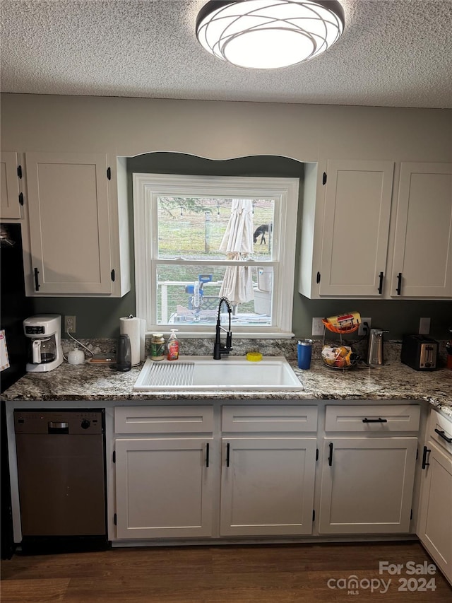 kitchen with dishwashing machine, sink, and white cabinets