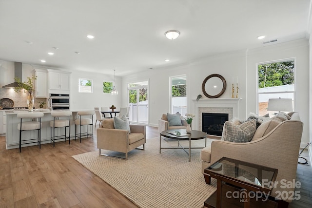 5230 Verona Rd Unit 80, Charlotte, NC 28213 - living area featuring light wood-style flooring, a brick fireplace, recessed lighting, and ornamental molding