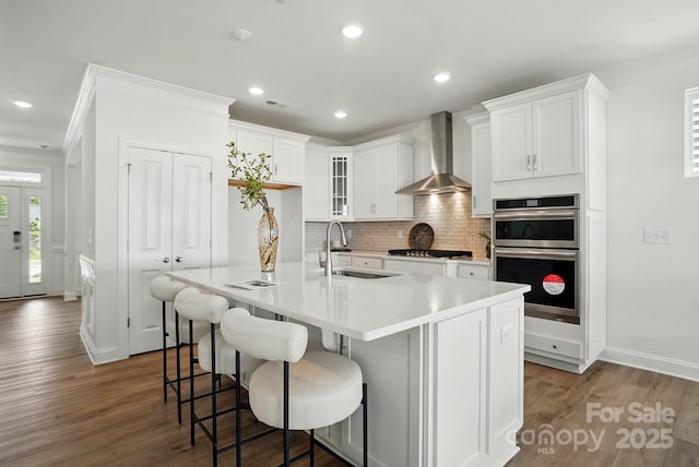 5230 Verona Rd Unit 80, Charlotte, NC 28213 - kitchen featuring wall chimney range hood, a sink, stainless steel appliances, tasteful backsplash, and light countertops