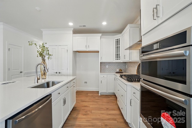 5230 Verona Rd Unit 80, Charlotte, NC 28213 - kitchen featuring a sink, appliances with stainless steel finishes, crown molding, light countertops, and light wood-style floors