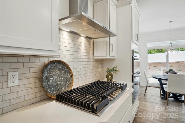 5230 Verona Rd Unit 80, Charlotte, NC 28213 - kitchen view of wall chimney range hood, white cabinetry, stainless steel gas cooktop, and backsplash