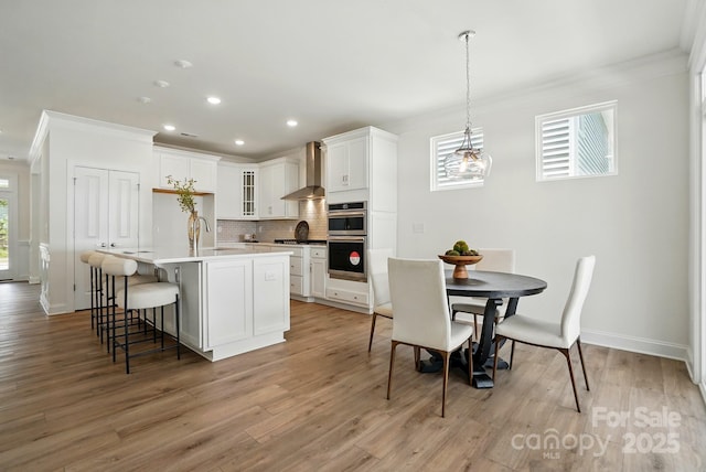 5230 Verona Rd Unit 80, Charlotte, NC 28213 - kitchen featuring ornamental molding, wall chimney range hood, decorative backsplash, a center island with sink, and recessed lighting
