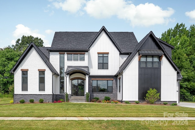 modern inspired farmhouse with a front lawn