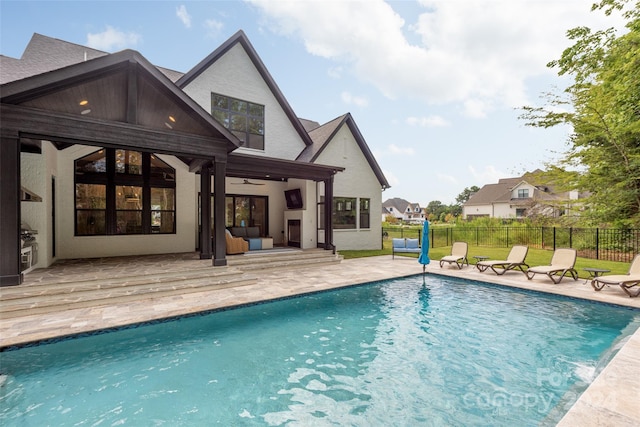 back of house featuring ceiling fan, a patio area, and a fenced in pool