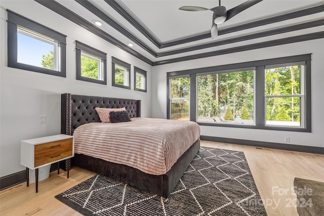 bedroom featuring multiple windows, ceiling fan, ornamental molding, and hardwood / wood-style flooring