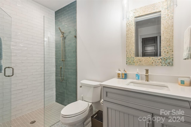 bathroom with a shower with door, vanity, and toilet