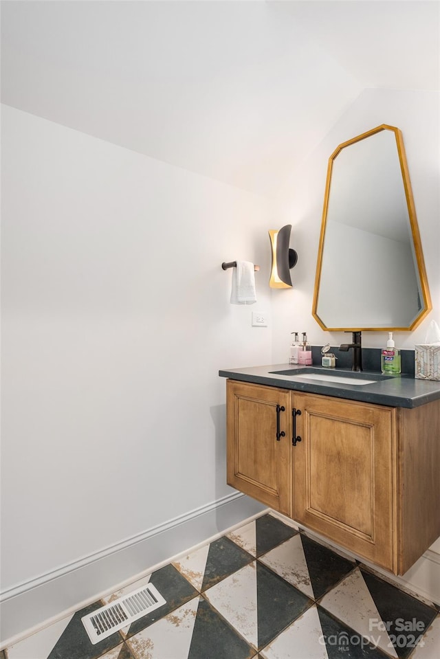 bathroom with vanity and lofted ceiling