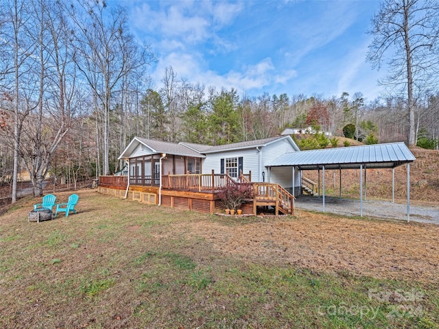 rear view of property with a deck and a carport