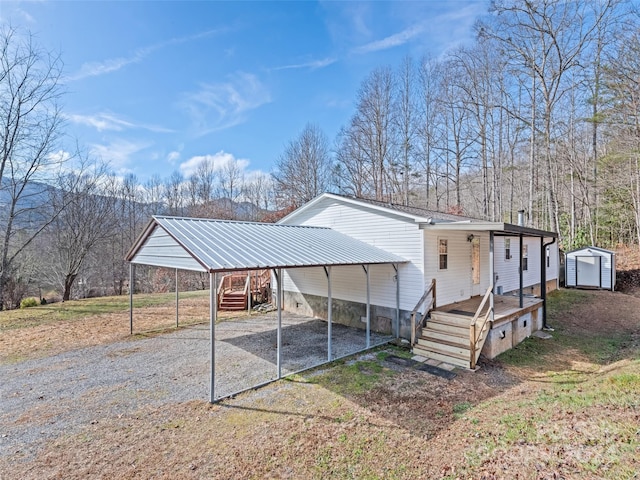 back of house with a carport and an outdoor structure