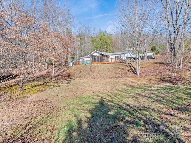 view of yard featuring a sunroom and a deck