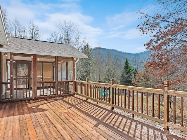 wooden terrace featuring a sunroom and a mountain view