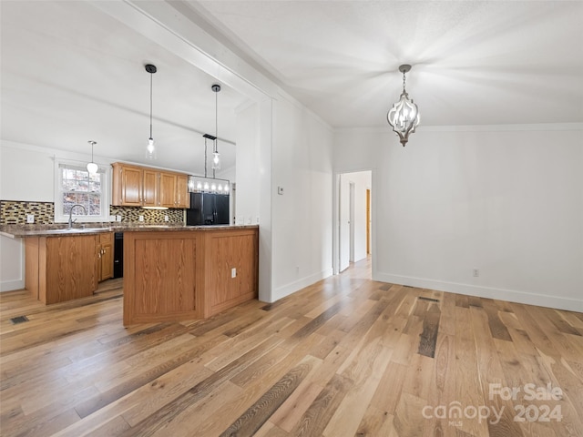 kitchen featuring tasteful backsplash, kitchen peninsula, pendant lighting, and light hardwood / wood-style floors