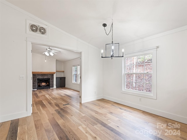 interior space with ceiling fan with notable chandelier, hardwood / wood-style flooring, vaulted ceiling, and crown molding