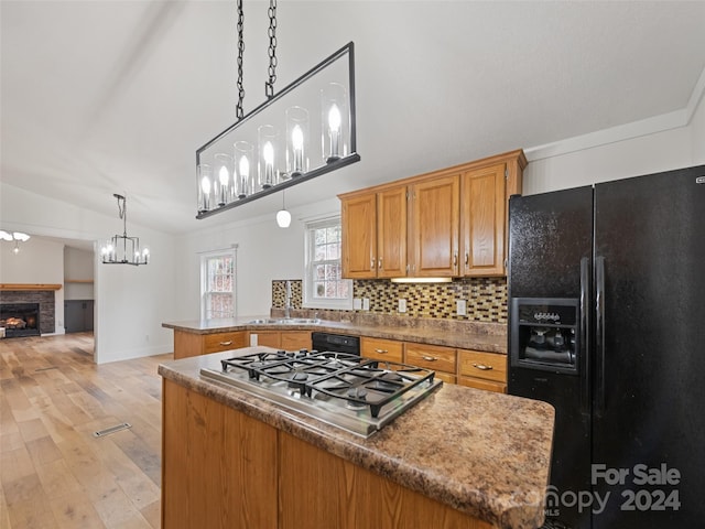 kitchen featuring a center island, lofted ceiling, black appliances, light hardwood / wood-style flooring, and decorative light fixtures