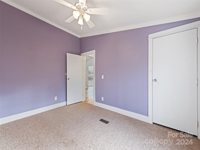 unfurnished bedroom featuring carpet flooring, ceiling fan, and ornamental molding