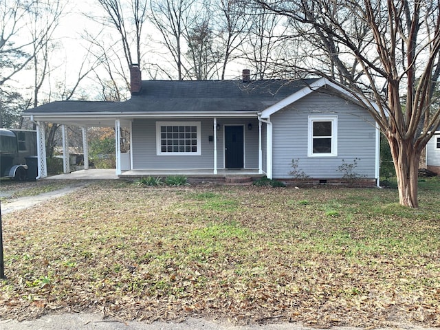 single story home featuring a carport, covered porch, and a front lawn