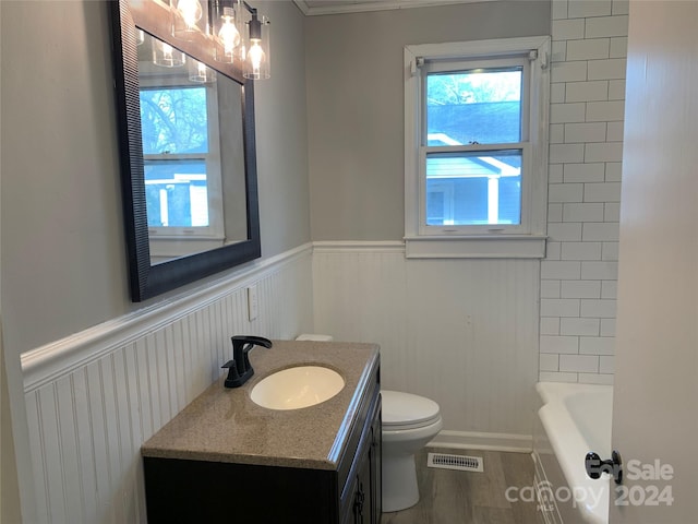 full bathroom featuring vanity, toilet, wood-type flooring, and shower with separate bathtub