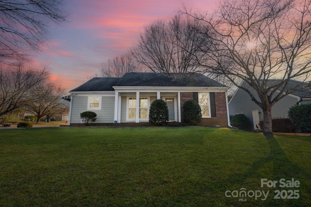 ranch-style home with a yard