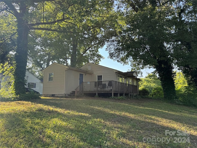 back of property featuring a yard and a deck