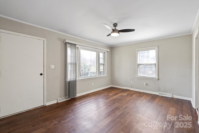 empty room featuring visible vents, baseboards, dark wood finished floors, ornamental molding, and a ceiling fan