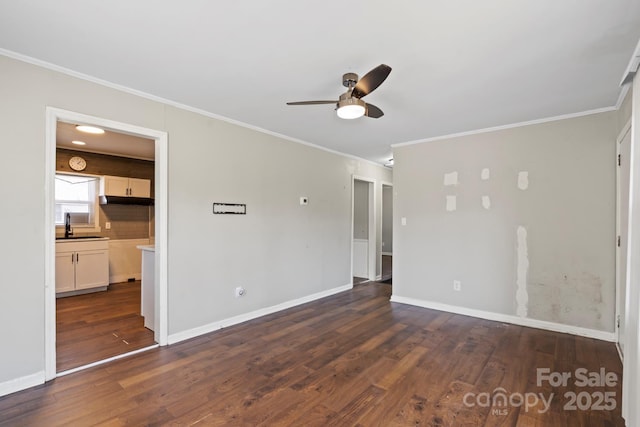 unfurnished living room with crown molding, baseboards, dark wood-type flooring, ceiling fan, and a sink