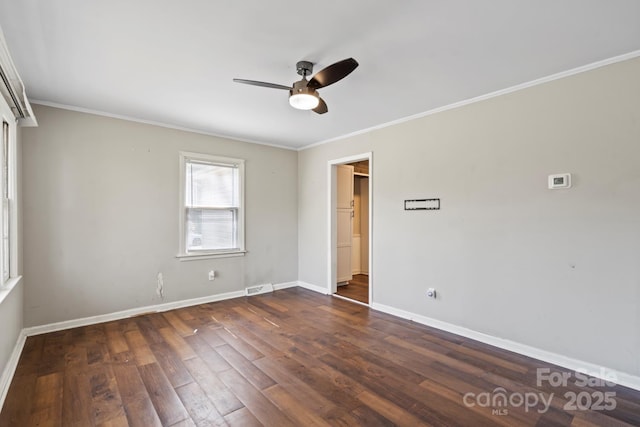 unfurnished room featuring visible vents, dark wood-type flooring, a ceiling fan, crown molding, and baseboards