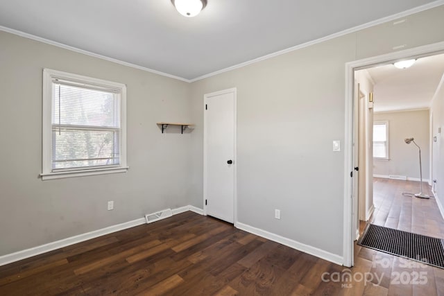 unfurnished bedroom with visible vents, multiple windows, and wood finished floors