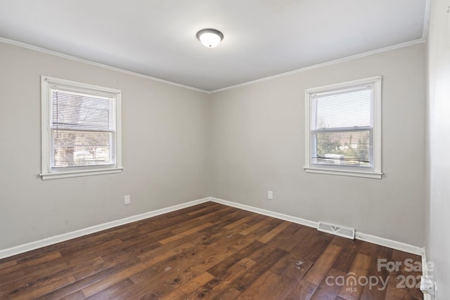 unfurnished room featuring dark wood-style flooring, baseboards, visible vents, and a wealth of natural light