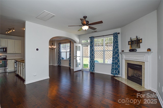 unfurnished living room with a premium fireplace, dark hardwood / wood-style floors, and ceiling fan