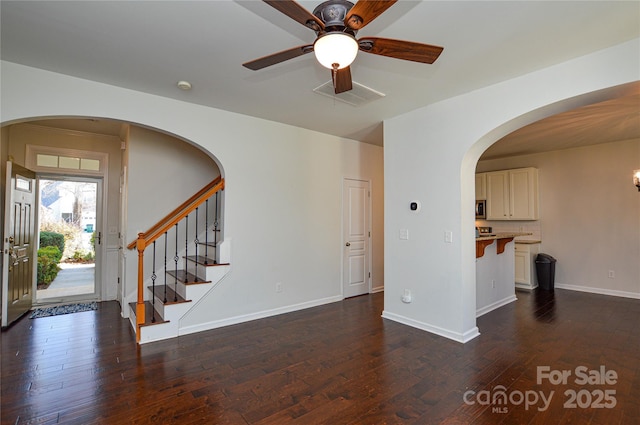 unfurnished living room with dark hardwood / wood-style floors and ceiling fan