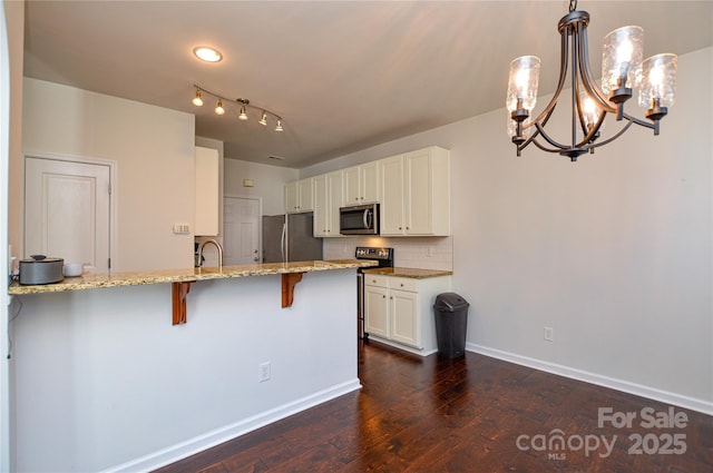 kitchen featuring white cabinetry, a breakfast bar, appliances with stainless steel finishes, and kitchen peninsula