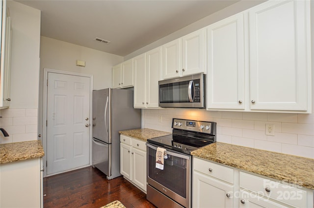 kitchen featuring tasteful backsplash, dark hardwood / wood-style flooring, stainless steel appliances, light stone countertops, and white cabinets