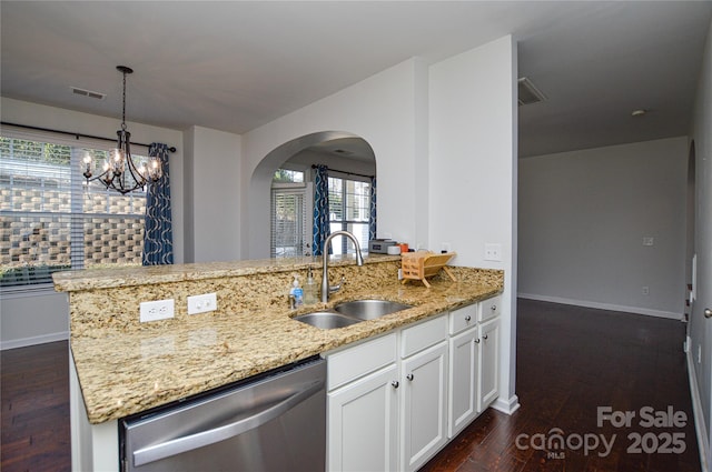 kitchen with pendant lighting, sink, white cabinets, stainless steel dishwasher, and light stone countertops