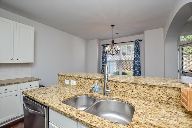 kitchen with sink, backsplash, hanging light fixtures, white cabinets, and stainless steel dishwasher