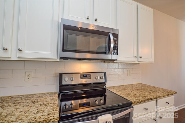 kitchen with tasteful backsplash, light stone countertops, stainless steel appliances, and white cabinets