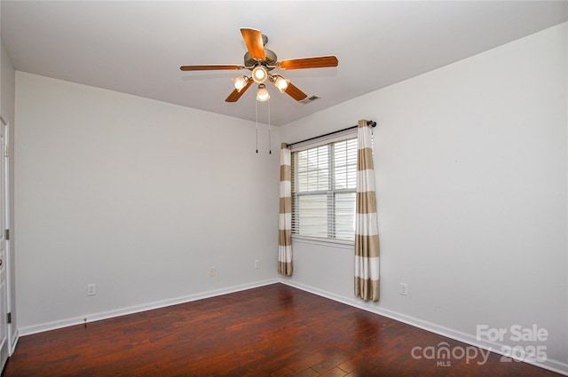 spare room with dark wood-type flooring and ceiling fan